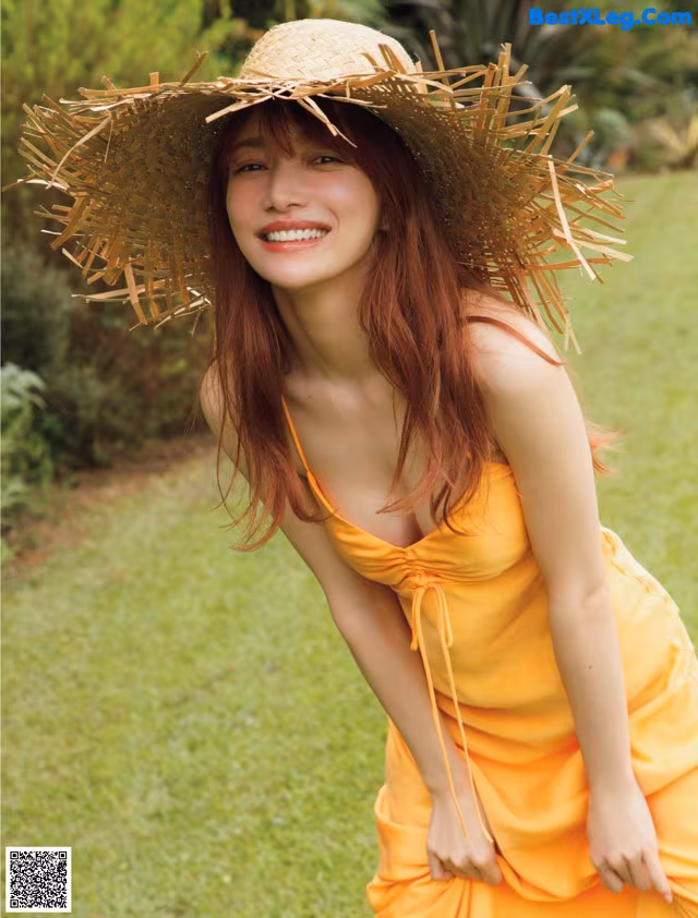 A woman in a yellow dress and a straw hat.