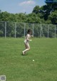 A woman in a bikini playing with a ball in a field.