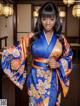 A woman in a blue and orange kimono posing for a picture.