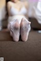 A woman laying on the floor with her feet up in white socks.