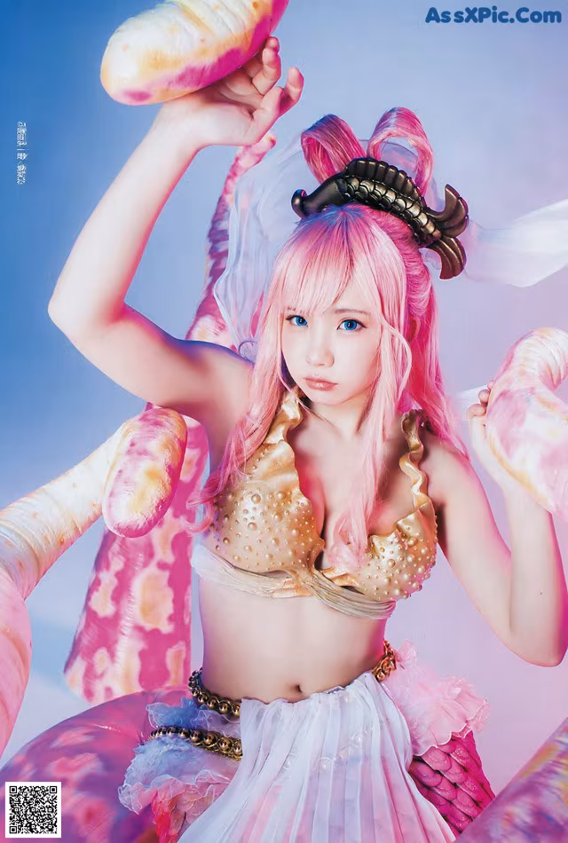 A woman in a pink and gold outfit holding a shell.
