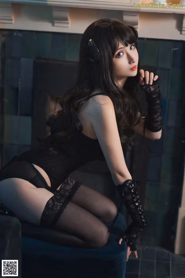 A woman in a black corset and stockings sitting on a chair.